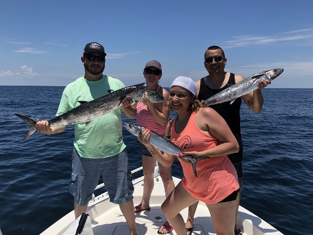 Four Individuals Holding Fishes