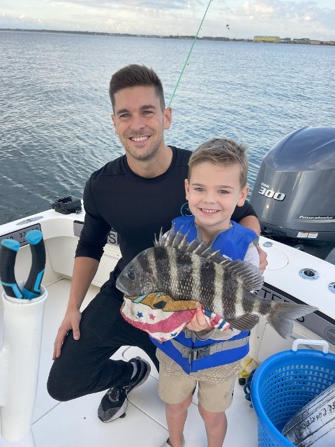 Father And Son Holding A Spiky Fish