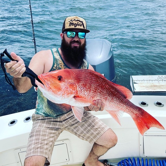 Man Holding A Big Orange Fish