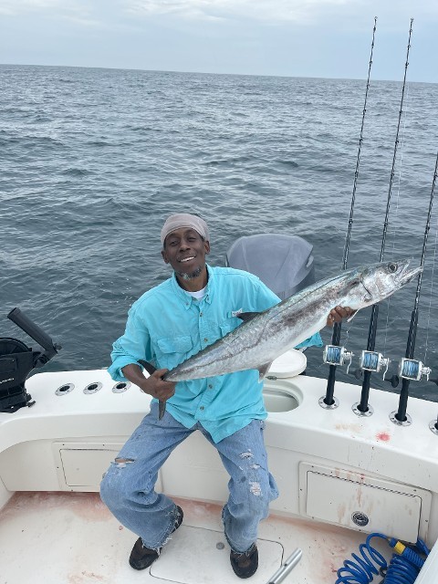 Happy Man In Blue Shirt Holding Fish