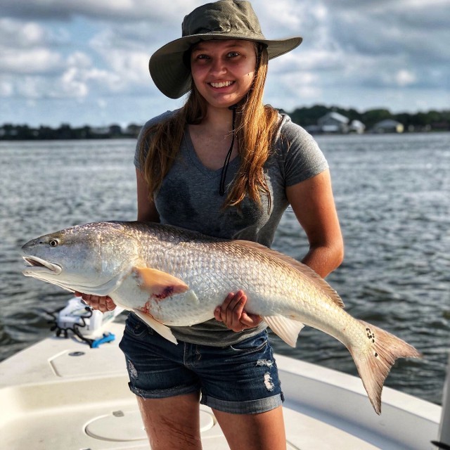 Woman With Hat Holding A Silver Fish