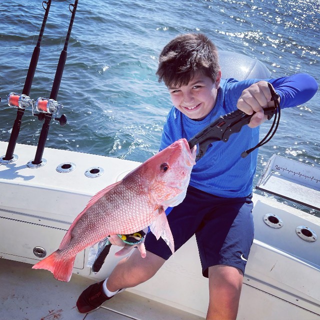 Happy Young Boy Holding A Fish