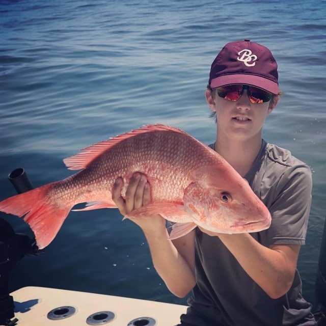 Teenager Holding A Big Orange Fish