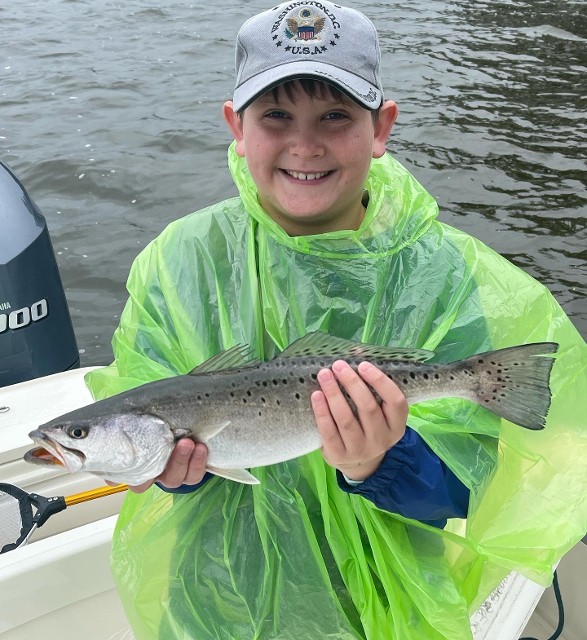 Boy On Raincoat Holding A Fish