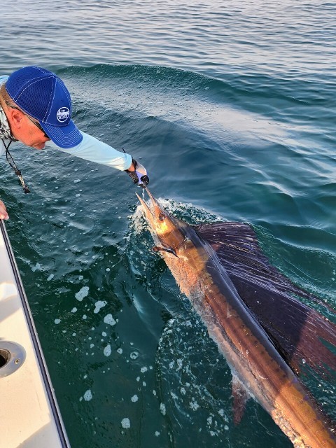 Man Holding A Fish On The Sea