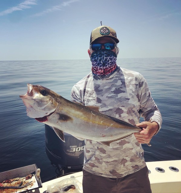 Masked Man Holding A Fish