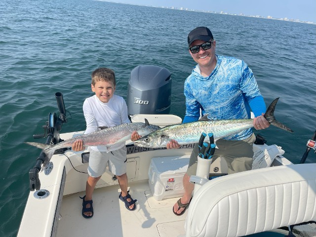 Father And Son Holding A Silver Fish