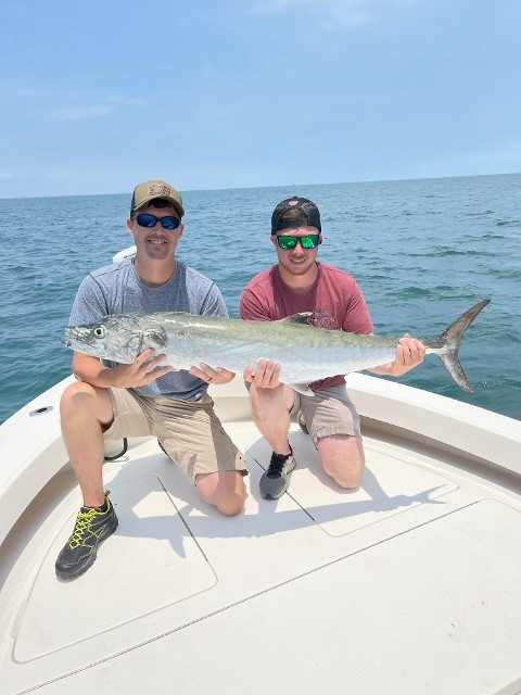 Two Man Smiling Holding A Big Fish