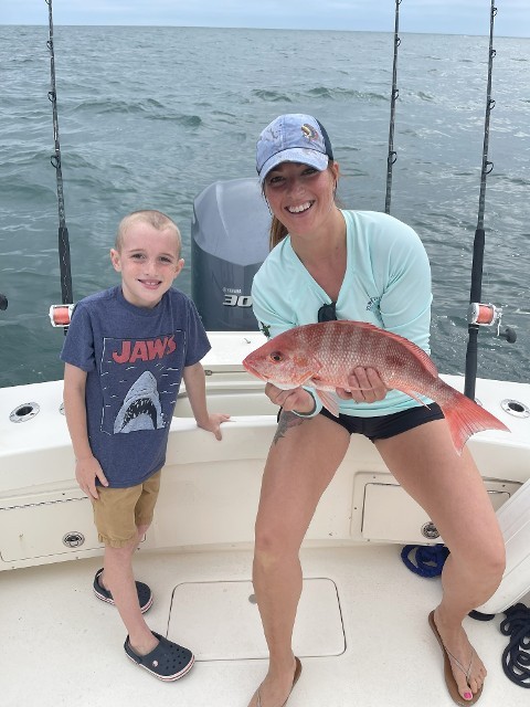 Mother And Son Smiling While Holding A Fish