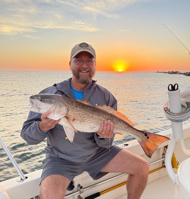 Man Holding A Big Fish On Sunset View