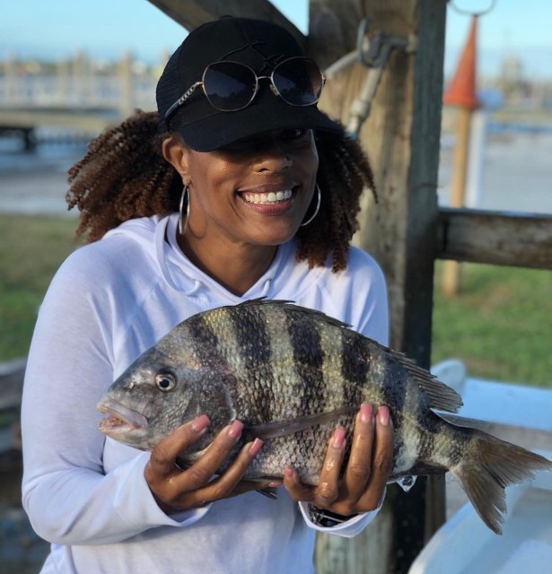 Woman Wearing Black Cap Holding Fish