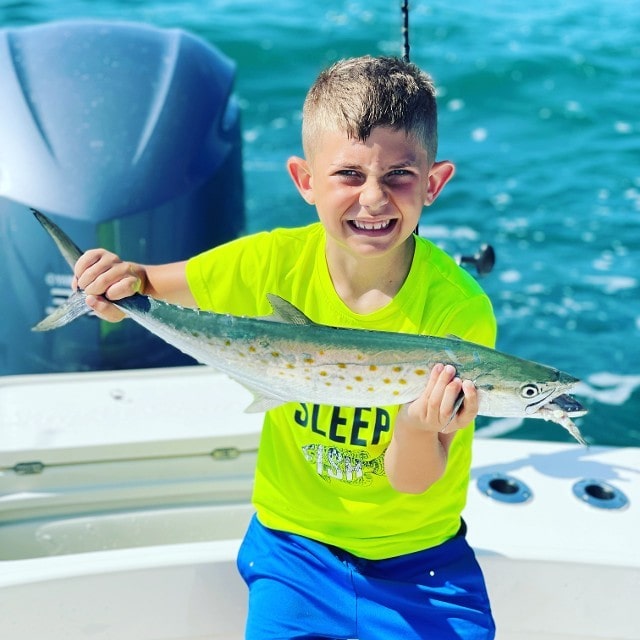 Boy In Green Thirt Holding A Big Fish