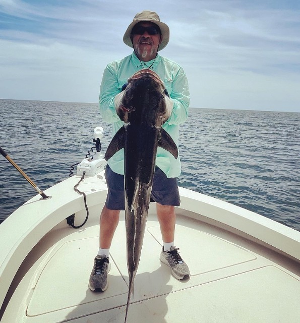 Man Wih Hat Holding A Big Fish