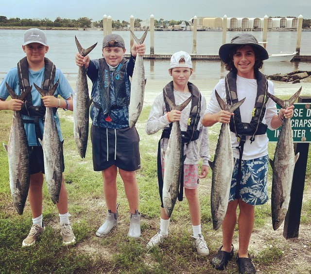 Four Young Boys Holding Fishes