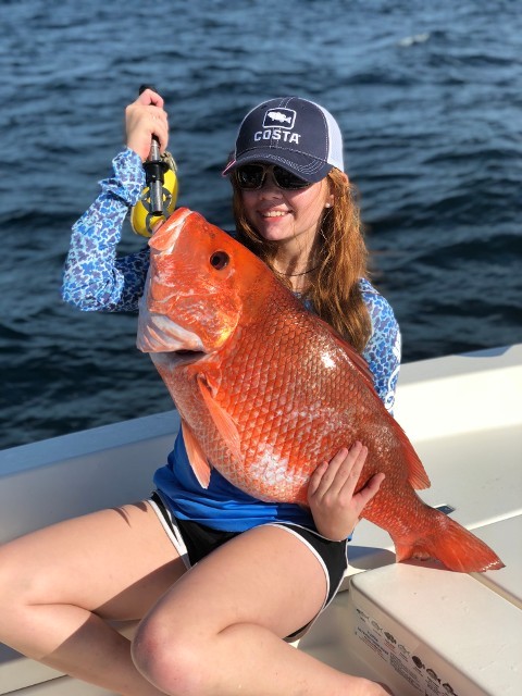 Woman Wearing A Hat Holding A Fish