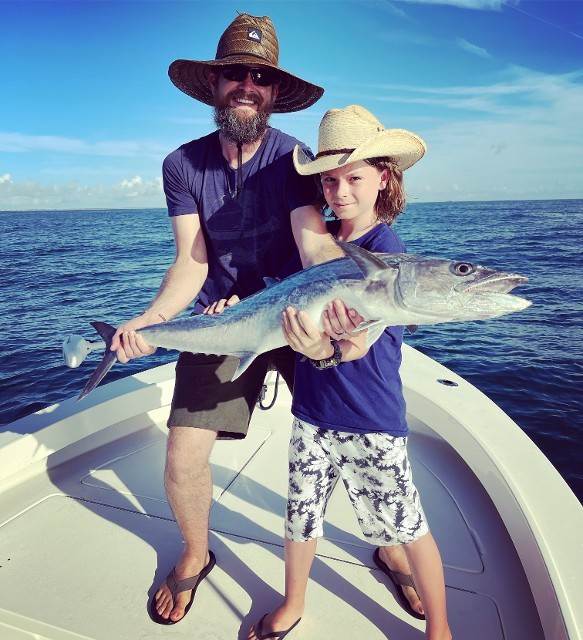 Father And Son In Cowboy Hat Holding A Big Fish