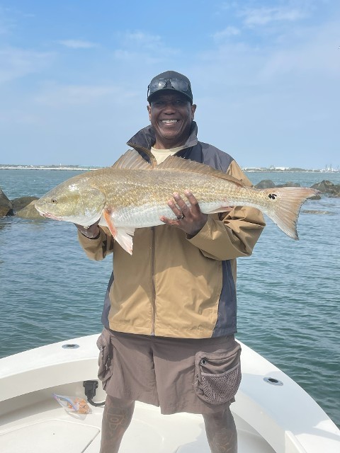 Happy Man In Brown Jacket Holding A Big Fish