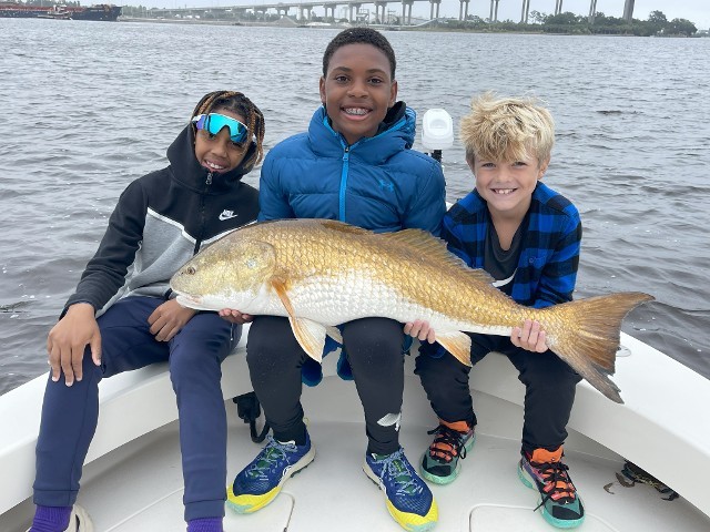 Three Young Boys Holding A Big Fish